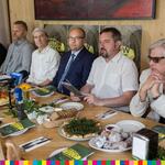 Siedem osób za stołem z jedzeniem. M.in. (od prawej): Piotr Tomaszuk, Radosław Dobrowolski, Artur Kosicki, Piotr Domagała.