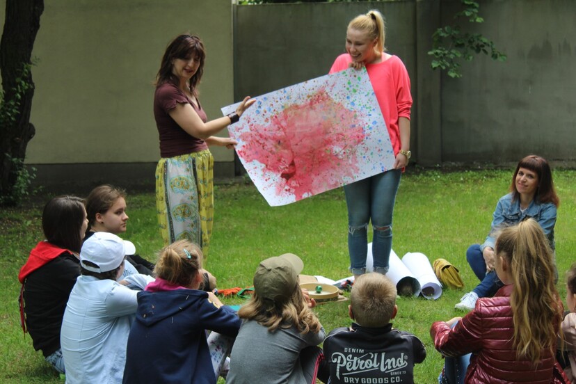 Wychowawczynie pokazują pracę plastyczną dzieciom Sztuka bez granic 2019 pierwszy weekend Zajecia.JPG