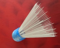 Biała lotka do badmintona na czerwonym tle