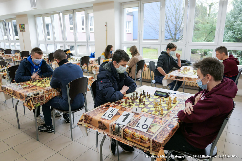 Zawodnicy szachowi z Liceum rozgrywają cztery pojedynki przy czterech stołach.