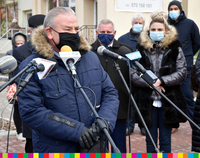 Wicemarszałek Województwa Podlaskiego Marek Olbryś mówi do mikrofonów, w tle stoją mężczyźni i kobiety