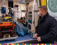 Marek Malinowski, członek Zarządu Województwa Podlaskiego. W tle wnętrze ambulansa ze sprzętem medycznym