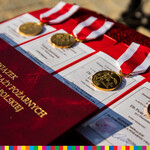 Złote medale z biało-czerwoną wstążką leżą na stole