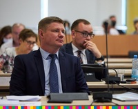 Marek Malinowski, członek zarządu, siedzący w sali sejmikowej, za nim inni radni