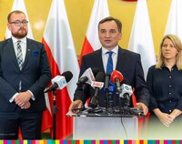 Minister Ziobro przemawia na tle flag. Tuż obok wicemarszałek Łukaszewicz i poseł Aleksandra Szczudło