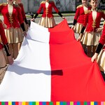 Dziewczynki trzymają biało czerwoną flagę 