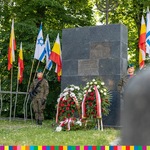 Pomnik synagogi, z obu stron stoją żołnierze, widoczne flagi 