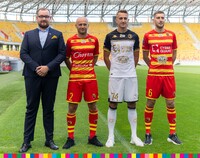 Wicemarszałek Sebastian Łukaszewicz stoi obok trzech piłkarzy w nowych strojach
