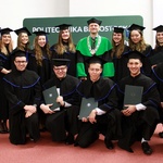 Grupa absolwentów Politechniki z władzami uczelni stoi w dwóch rzędach podczas pozowania do pamiątkowego zdjęcia