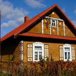 Drewniana chata wiejska z ozdobnymi okiennicami
