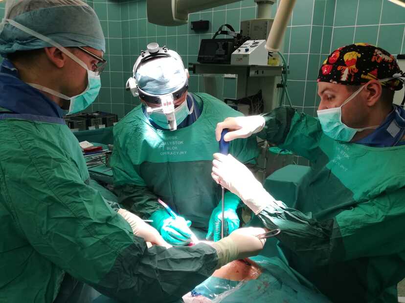 trzech chirurgów na sali operacyjnej podczas operacji kręgosłupa