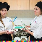 Dwie dziewczyny w strojach kucharzy trzymające talerze z daniem