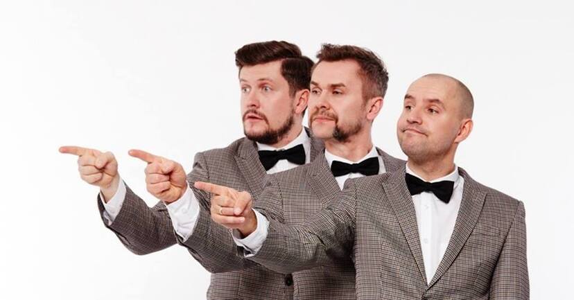na zdjęciu trzech mężczyzn z grupy Fair Play Crew stoją jeden za drugim ubrani w jasne garnitury i muszki i wszyscy trzej wskazują palcem w jednym kierunku