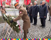 ul.Mazowiecka, żołnierz ustawia biało-czerwony wieniec pod tablicą upamiętniającą prezydenta R. Kaczorowskiego. Przed nią stoją marszałek województwa, wojewoda podlaski, przewodniczący sejmiku.