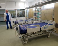 Pracownik szpitala przy oddziałowych łóżkach