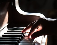 Ręka nad klawiaturą fortepianu