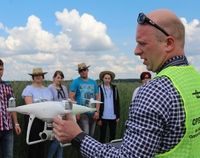Prowadzący szkolenie prezentuje drona młodzieży