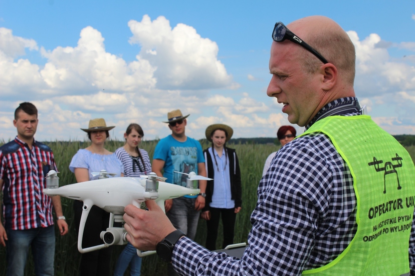 Prowadzący szkolenie prezentuje drona młodzieży