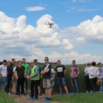 Grupa młodzieży, przed nimi w powietrzu dron