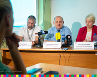 Trzej uczestnicy konferencji siedzący za stołem. W środku Przemysław Sarosiek, dyrektor białostockiego WORD. Przed nimi mikrofony mediów.