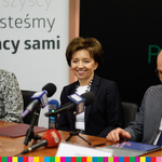 Marlena Maląg, prezes PFRON, marszałek Artur Kosicki i Grażyna Bogdańska, siedzący za stołem prezydialnym. 