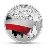 Rewers monety przedstawiający grupę ludzi nad biało-czerwoną flagą, pod nią odbicie jest odbicie tej grupy, wokół obrzeża napis: 100-lecie polskiej flagi państwowej