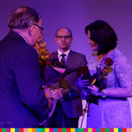 Marszalek Artur Kosicki stoi obok dwóch kobiet i mężczyzny. Kobieta po prawej stronie trzyma różę i dyplom.