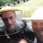 Dwie osoby w strojach pszczelarzy.