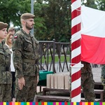 Dwójka żołnierzy obok powiewającej flagi Polski