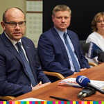 Marszałek Artur Kosicki i członek zarządu Marek Malinowski siedzą za stołem obok kobiety.