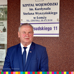 Wicemarszałek Marek Olbryś stoi przed wejściem do łomżyńskiego szpitala.