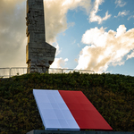 Pomnik Westerplatte z rozłożoną przed nim Polską flagą.