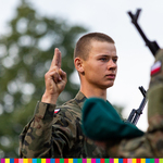 Żołnierz trzyma dłoń uniesioną w geście przysięgi.