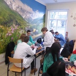 Uczniowie dokonujący eksperymentów w trakcie zajęć lekcyjnych pod okiem nauczyciela