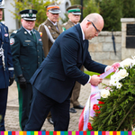 Marszałek Artur Kosicki w asyście przedstawicieli służb mundurowych sklada wieniec przed Grobem Nieznanego Sybiraka.
