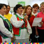 Grupa śpiewających kobiet ubranych w stroje ludowe.