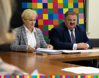 Stanisław Derehajło, Wicemarszałek Województwa Podlaskiego i Agnieszka Aleksiejczku, Dyrektor Departamentu Społeczeństwa Informacyjnego UMWP siedzą przy stole z dokumentami.