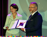 Wiceminister kultury Magdaleny Gawin i dyrektor Artur Gaweł trzymają oprawiony medal.