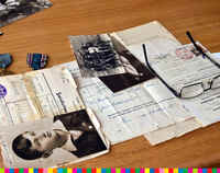 Stare dokumenty i zdjęcia leżące na stole.