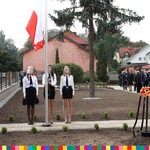Trzy dziewczęta stojące przy maszcie z flagą Polski
