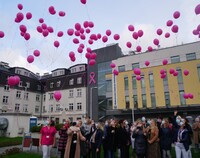 Zebrane przed budynkiem BCO osoby wypuszczają balony w górę.