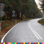Fragment wyremontowanej drogi. Na poboczu stoją znaki drogowe