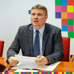 Marek Malinowski, członek zarządu, siedzi przy stole, w dłoniach trzyma kartkę