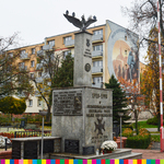 Pomnik na 80-lecie odzyskania niespodległości przez Polskę, a w tle blok z namalowanym muralem na szczytowej ścianie