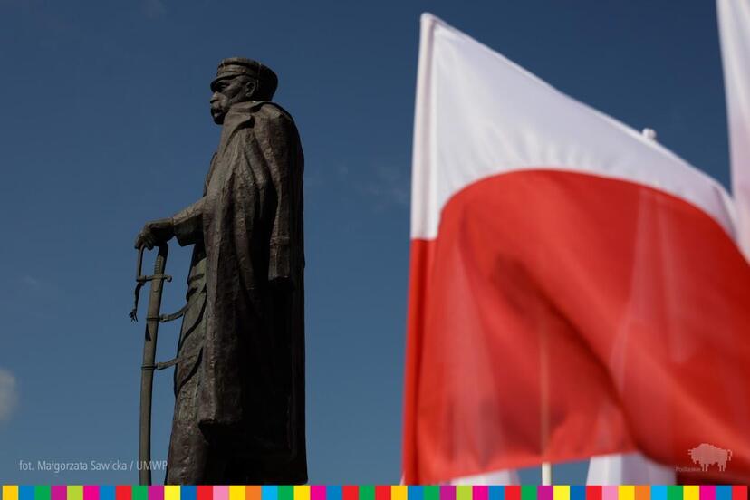 Po lewej pomnik Józefa Piłsudskiego. Obok widoczna flaga biało-czerwona.