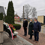 Dwójka mężczyzn i kobieta stojących przed pomnikiem