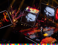 Marek Piekarczyk śpiewający na scenie i wyświetlane na telebimach zdjęcia Jana Pawła II