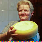 Kobieta trzyma w rękach okrągły ser.