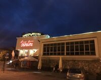 Widok na restaurację Albatros w Augustowie. Wieczór. Rozświetlony napis Albatros