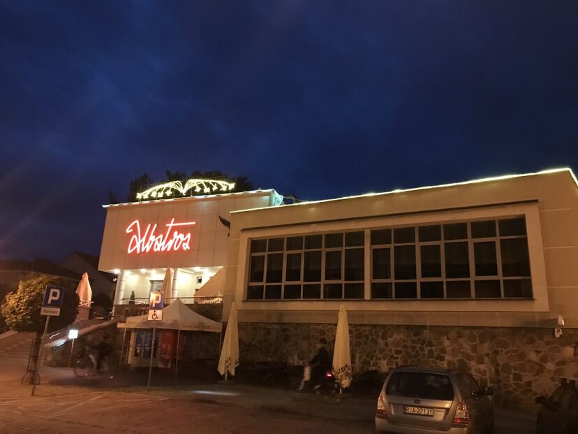 Widok na restaurację Albatros w Augustowie. Wieczór. Rozświetlony napis Albatros
